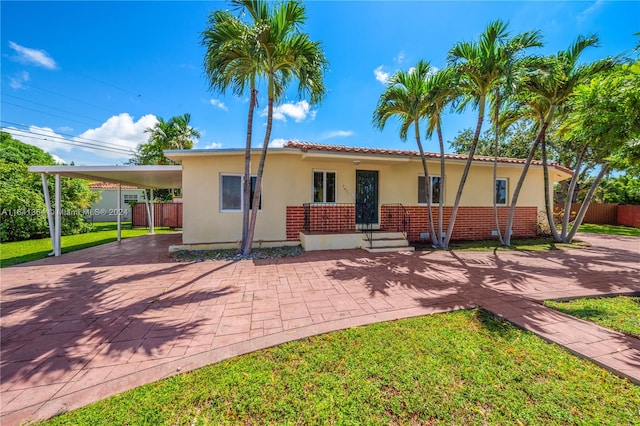 view of front of property featuring a carport and a front yard