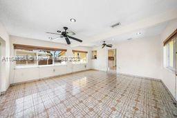 empty room with tile patterned floors and ceiling fan