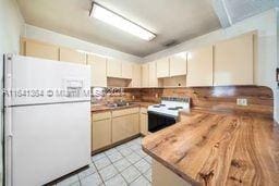 kitchen with white appliances and light tile patterned flooring