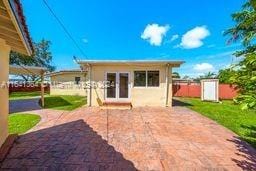 back of property with a patio area and an outbuilding