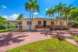 view of front of house featuring a front lawn and a carport