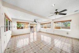 unfurnished living room featuring beam ceiling, light tile patterned floors, and ceiling fan