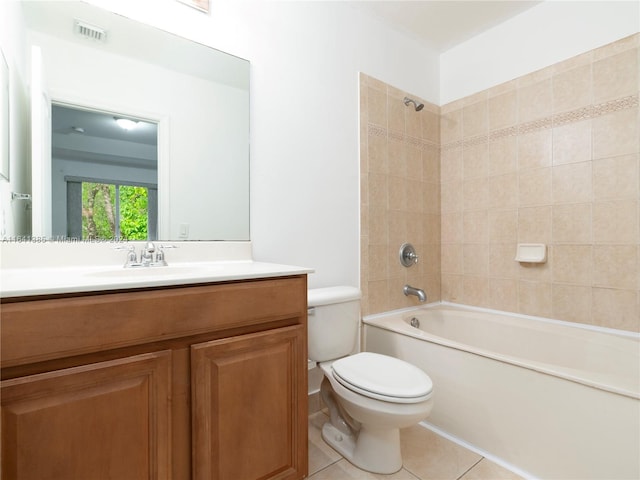 full bathroom featuring toilet, vanity, tiled shower / bath combo, and tile patterned floors