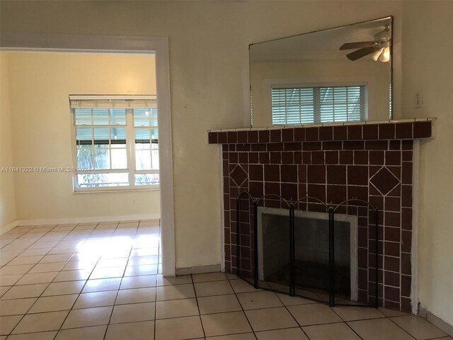 details with a fireplace, ceiling fan, and tile patterned floors