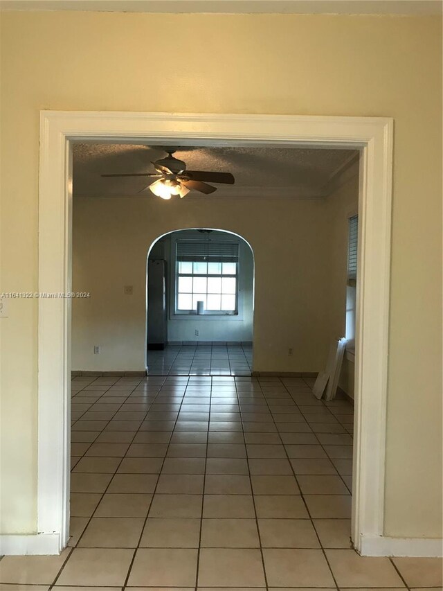 tiled spare room featuring ceiling fan