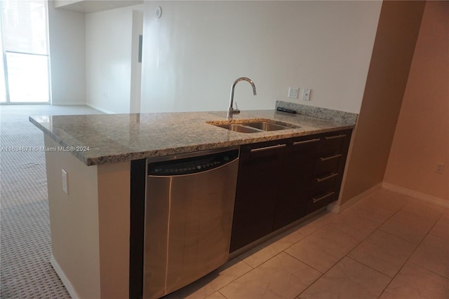 kitchen featuring dishwasher, light stone counters, light tile patterned floors, and sink