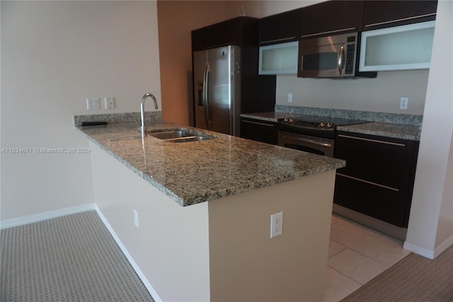 kitchen featuring sink, stainless steel appliances, light stone counters, and kitchen peninsula