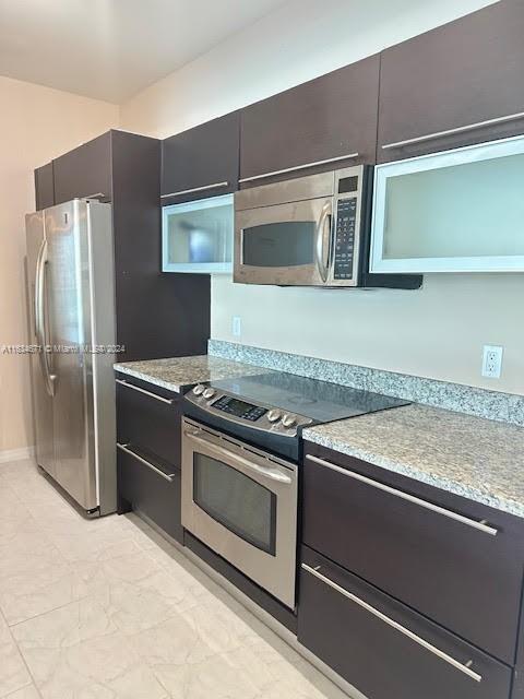 kitchen with light tile patterned flooring and stainless steel appliances