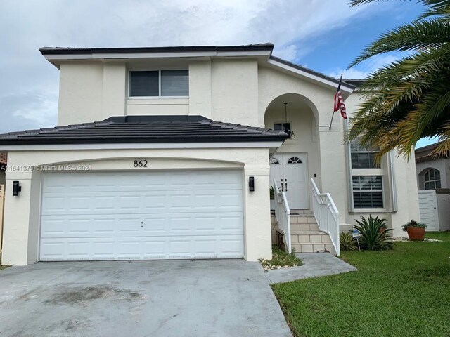 view of front of property featuring a front lawn and a garage