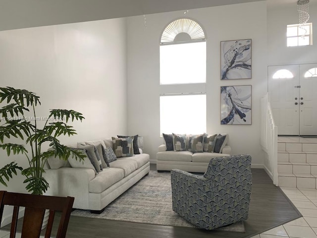 tiled living room featuring a high ceiling and a healthy amount of sunlight