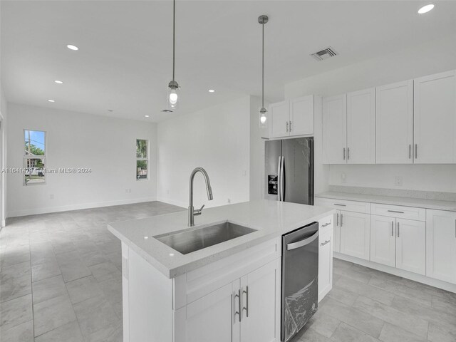 kitchen with light tile patterned floors, appliances with stainless steel finishes, white cabinets, sink, and decorative light fixtures