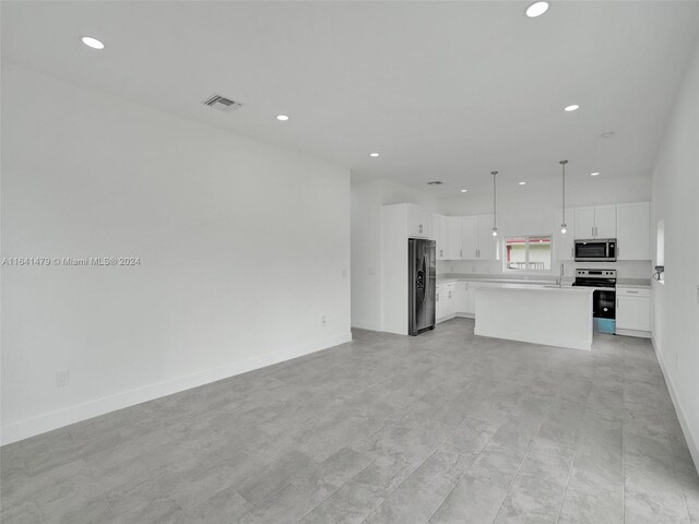 unfurnished living room featuring light tile patterned flooring and sink