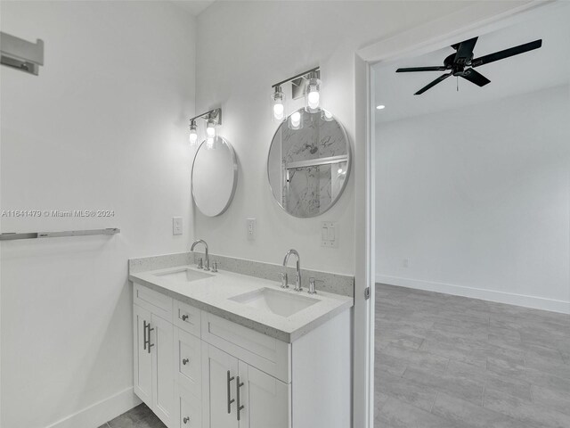 bathroom with ceiling fan, double sink vanity, and tile patterned flooring