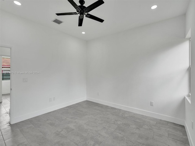 empty room with ceiling fan and light tile patterned flooring