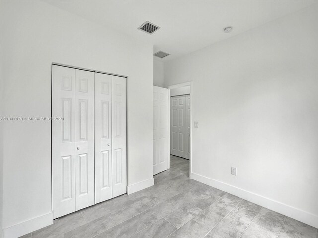 unfurnished bedroom with a closet and light tile patterned floors