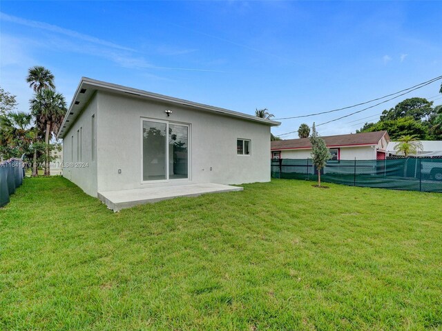 rear view of house with a lawn and a patio area