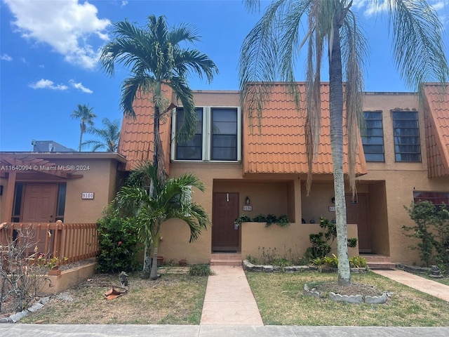 multi unit property featuring a tile roof and stucco siding