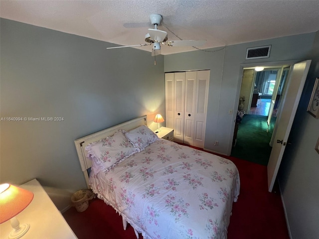 bedroom with visible vents, ceiling fan, dark colored carpet, a textured ceiling, and a closet