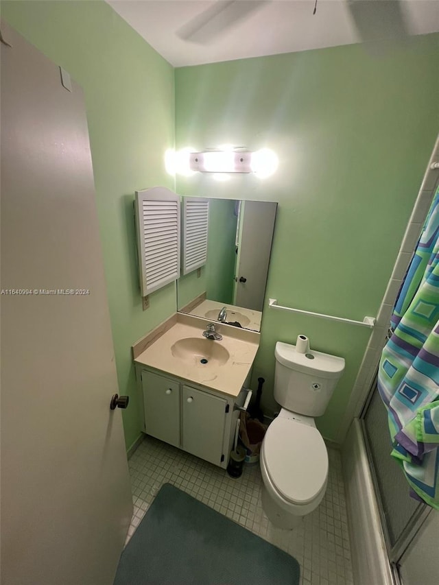 full bath featuring toilet, curtained shower, vanity, and tile patterned floors