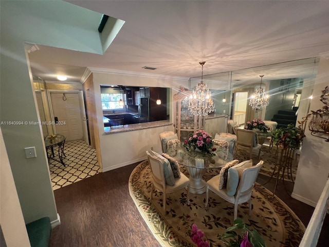 dining space featuring ornamental molding, a chandelier, visible vents, and wood finished floors