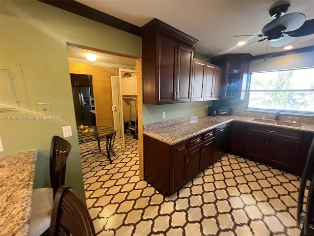 kitchen featuring stainless steel fridge, light countertops, dark brown cabinets, light floors, and a sink