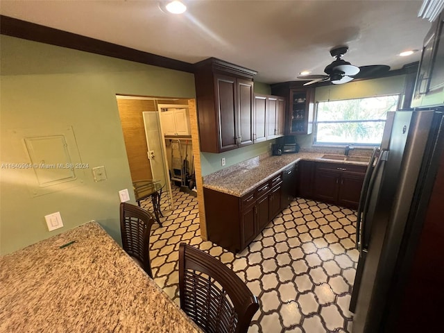 kitchen featuring ceiling fan, a sink, dark brown cabinets, freestanding refrigerator, and dishwasher