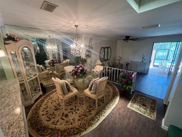 dining room with ceiling fan with notable chandelier, dark wood-style flooring, visible vents, and crown molding