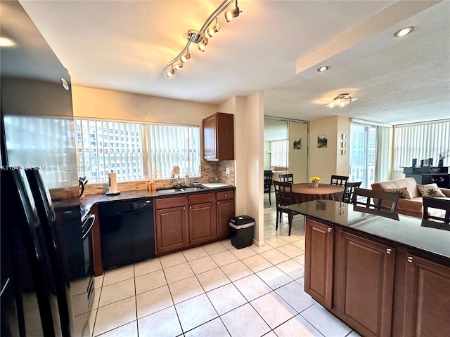 kitchen with track lighting, dishwasher, light tile patterned flooring, tasteful backsplash, and sink