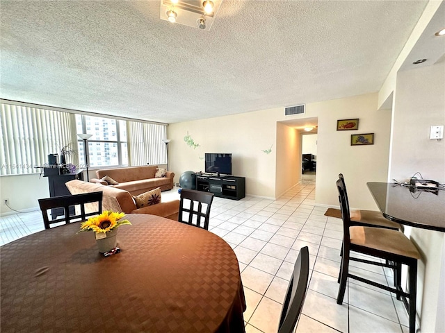 dining space featuring light tile patterned flooring and a textured ceiling