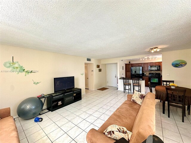 tiled living room featuring a textured ceiling