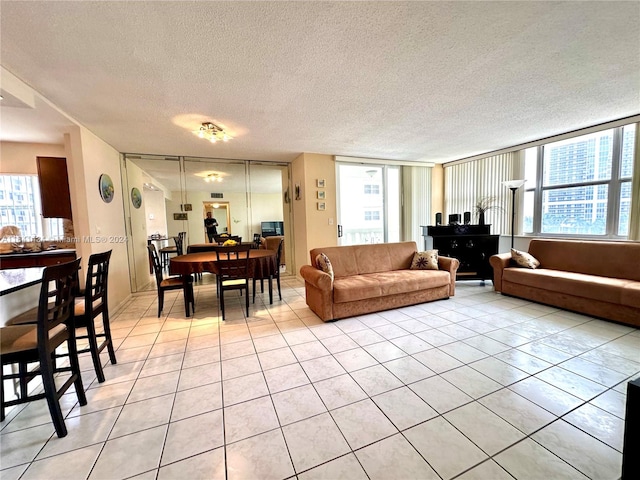 living room with light tile patterned flooring, a textured ceiling, and a wealth of natural light