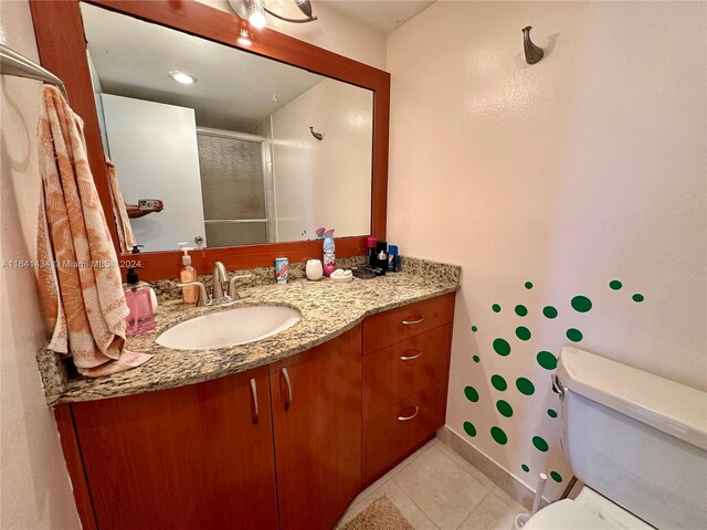 bathroom featuring toilet, vanity, and tile patterned flooring