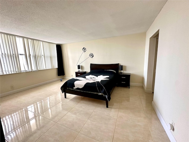 bedroom featuring light tile patterned floors and a textured ceiling