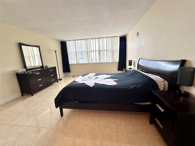 bedroom with a textured ceiling and light tile patterned floors