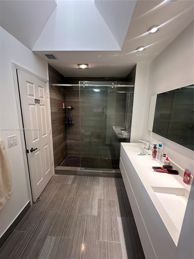 bathroom featuring walk in shower, dual bowl vanity, and tile patterned floors