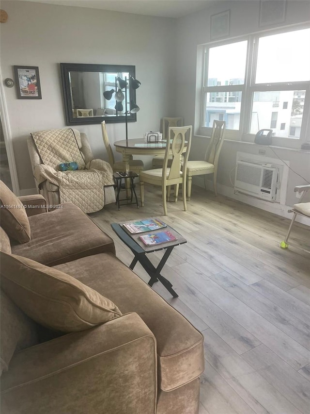 living room with light wood-type flooring and an AC wall unit