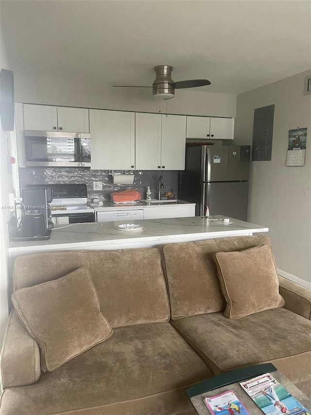 kitchen with ceiling fan, white cabinetry, appliances with stainless steel finishes, and backsplash