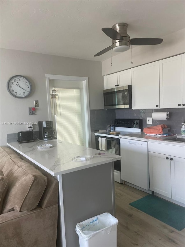 kitchen with dark hardwood / wood-style flooring, decorative backsplash, electric range oven, dishwasher, and ceiling fan