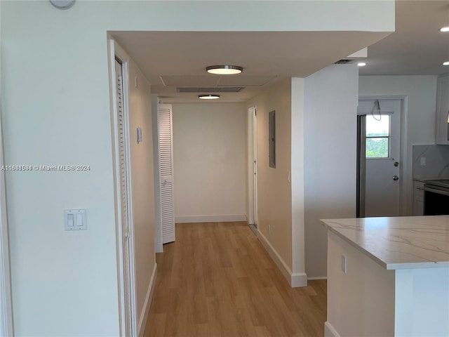 corridor featuring light hardwood / wood-style floors and electric panel