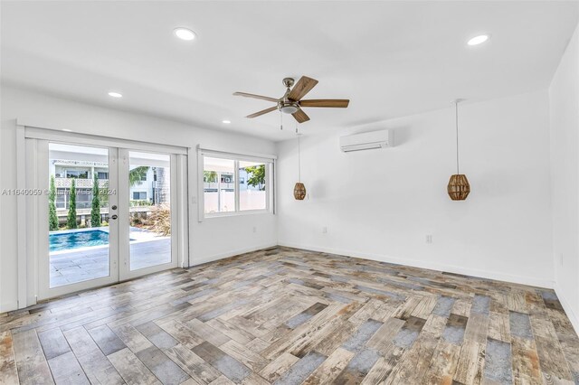 spare room with french doors, a wall mounted AC, and ceiling fan