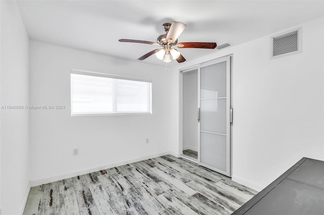 unfurnished bedroom with ceiling fan, light hardwood / wood-style flooring, and a closet