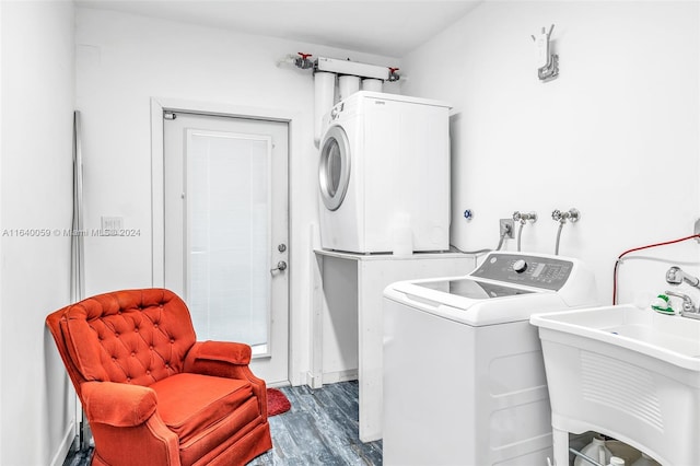 laundry area with sink, wood-type flooring, and stacked washer / dryer