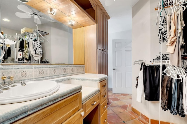 bathroom featuring ceiling fan, vanity, wood ceiling, and decorative backsplash