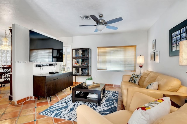 tiled living room with a wealth of natural light and ceiling fan