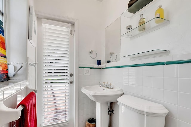 bathroom with tile walls and toilet