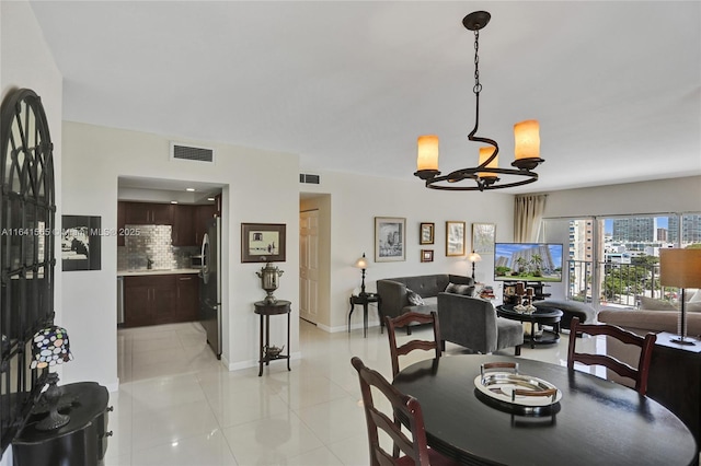 tiled dining space with a chandelier