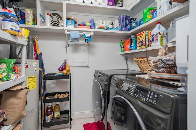 clothes washing area with water heater, washing machine and dryer, and light tile patterned floors