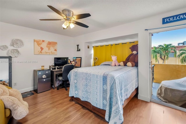 bedroom with access to exterior, a textured ceiling, ceiling fan, and light hardwood / wood-style floors