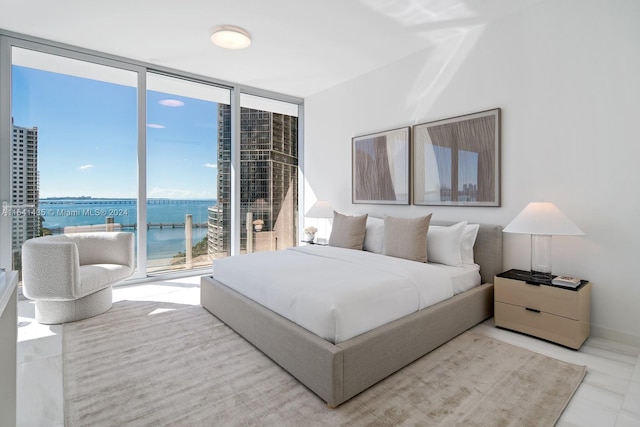 bedroom featuring a water view and expansive windows