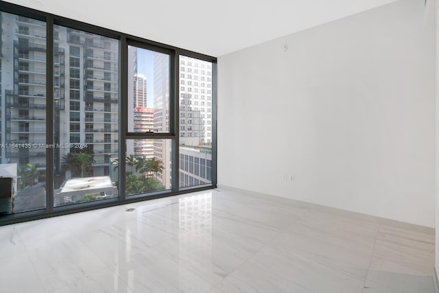 unfurnished room with a wall of windows